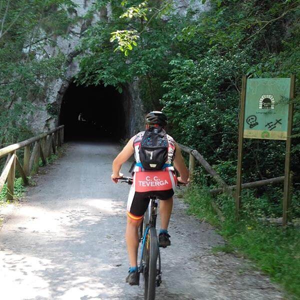 Persona en bicicleta entrando en un túnel de la Senda del Oso, en Teverga, Asturias